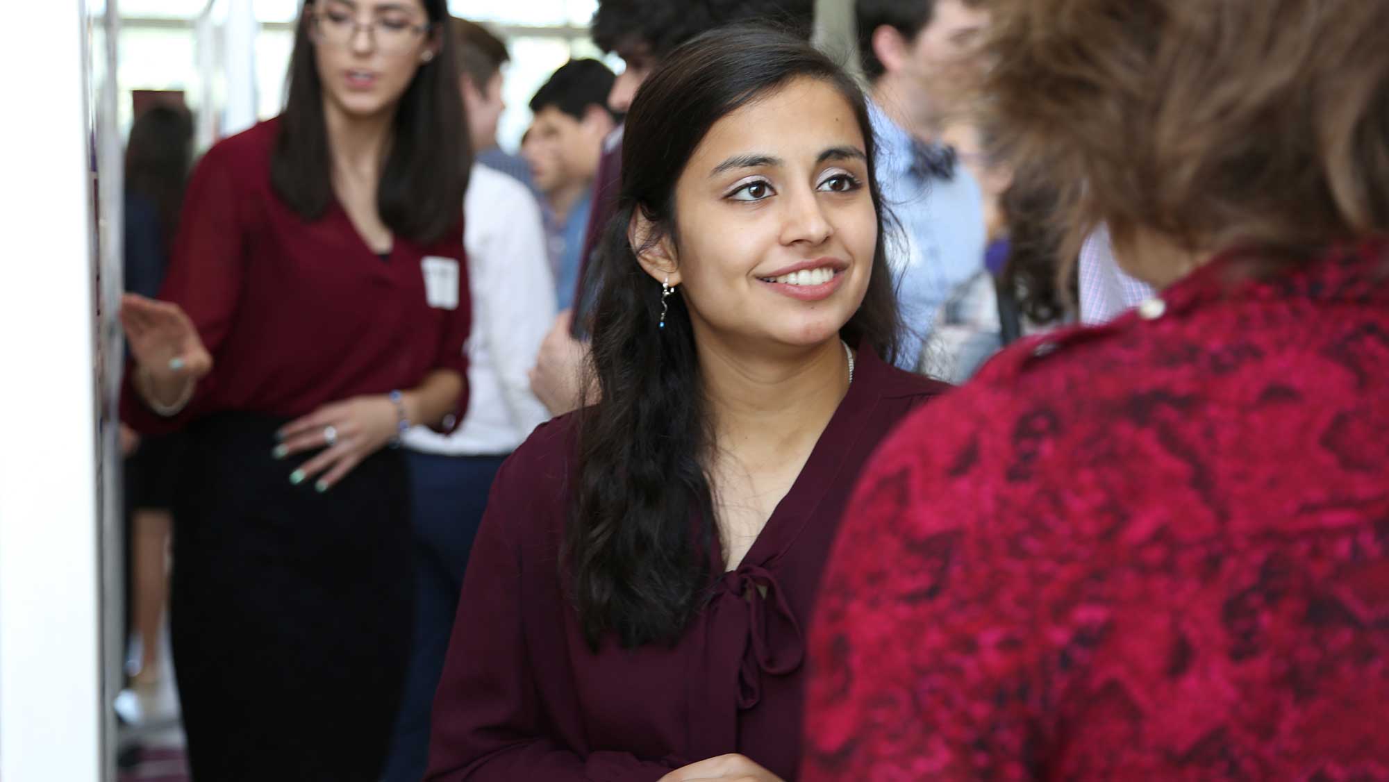 engineering students networking at a project showcase