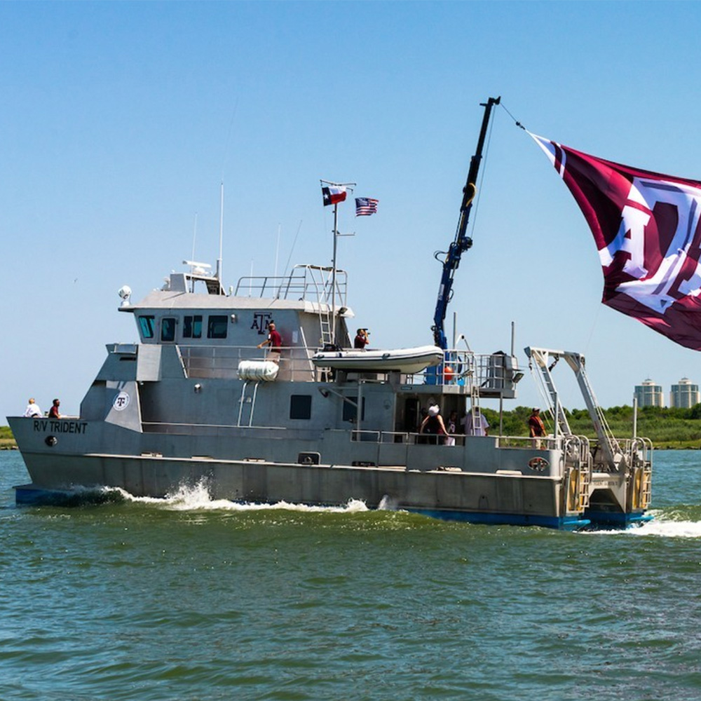 Large boat with name R/V Trident and flying Texas A&M flag
