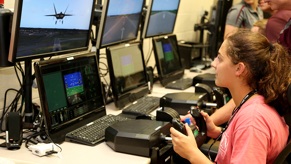 翱翔营的参与者控制着一架模拟喷气式飞机。