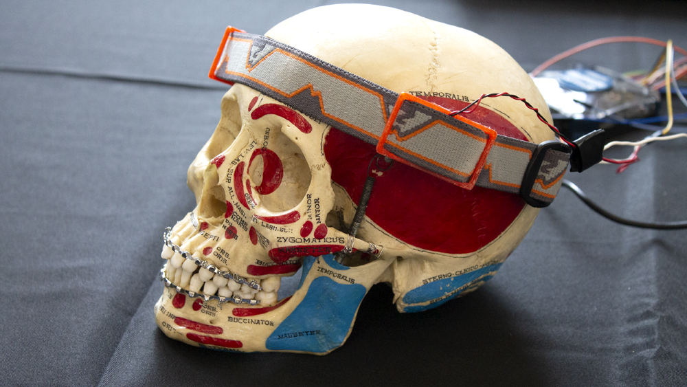 一个头骨模型，用绷带缠在头上，演示医疗设备的使用