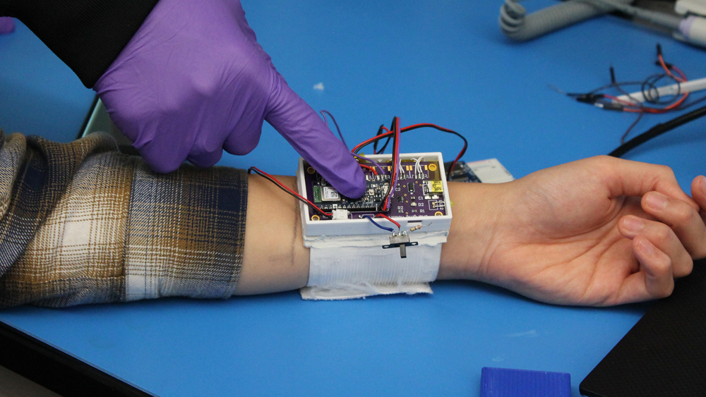 学生在实验室中研究可穿戴手腕装置的电路