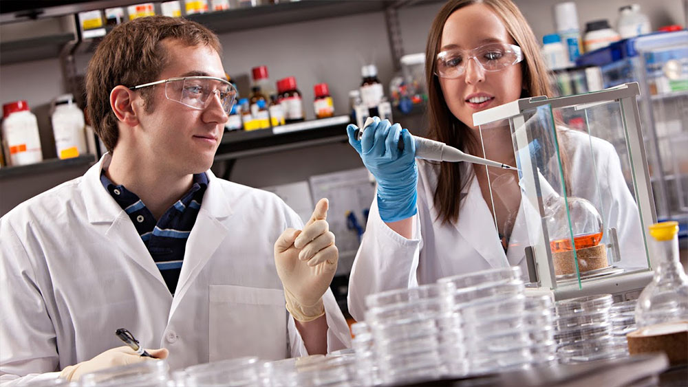 穿着白大褂的生物医学学生在实验室进行研究