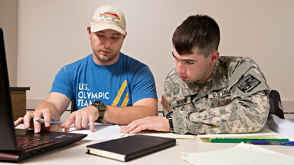 两个男学生，其中一个穿着美国军装在一起学习。