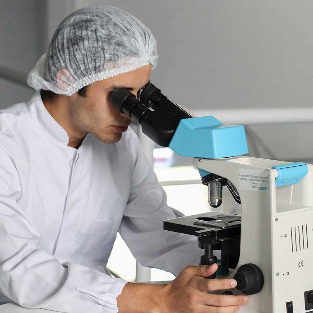 学生实验室技术员使用直立显微镜。
