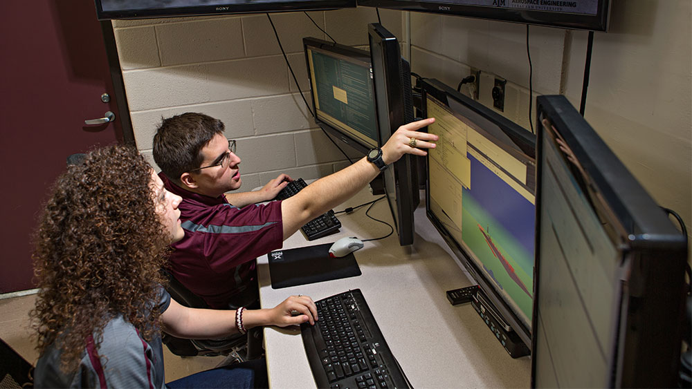 Student in a lab typing on a Mac laptop.