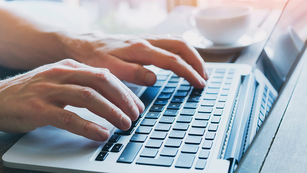 person typing on laptop keyboard