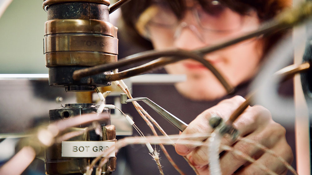 A male student works with lab equipment in a materials science and engineering lab.