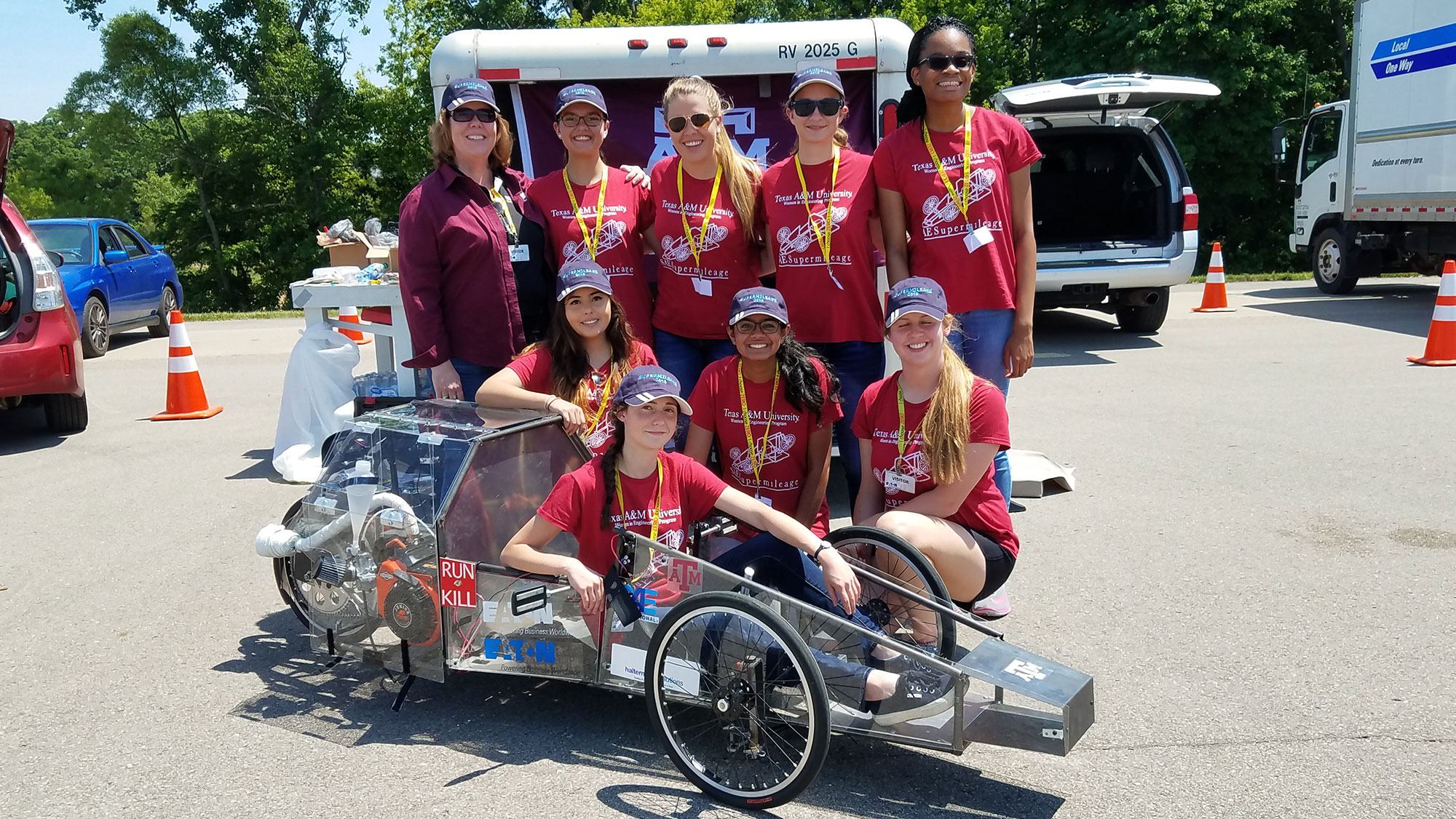 Women in Engineering Supermileage vehicle student team with vehicle.